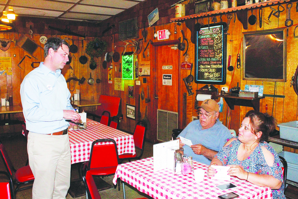Conner Eldridge, the Democratic candidate for U.S. Senate, visits with Jose Tijerina and Lety Hendrix at the Mount Ida Cafe. He stopped by the cafe and the courthouse as he traveled through the area on his “Hear Arkansas’s Voices” tour.  Photo by Dewayne Holloway