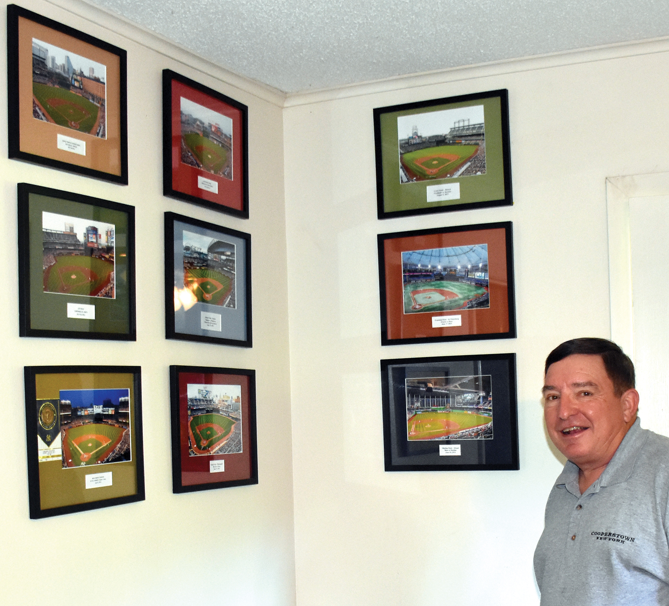 Johnny Wilson displays photos of some of the 30 MLB parks he has visited.