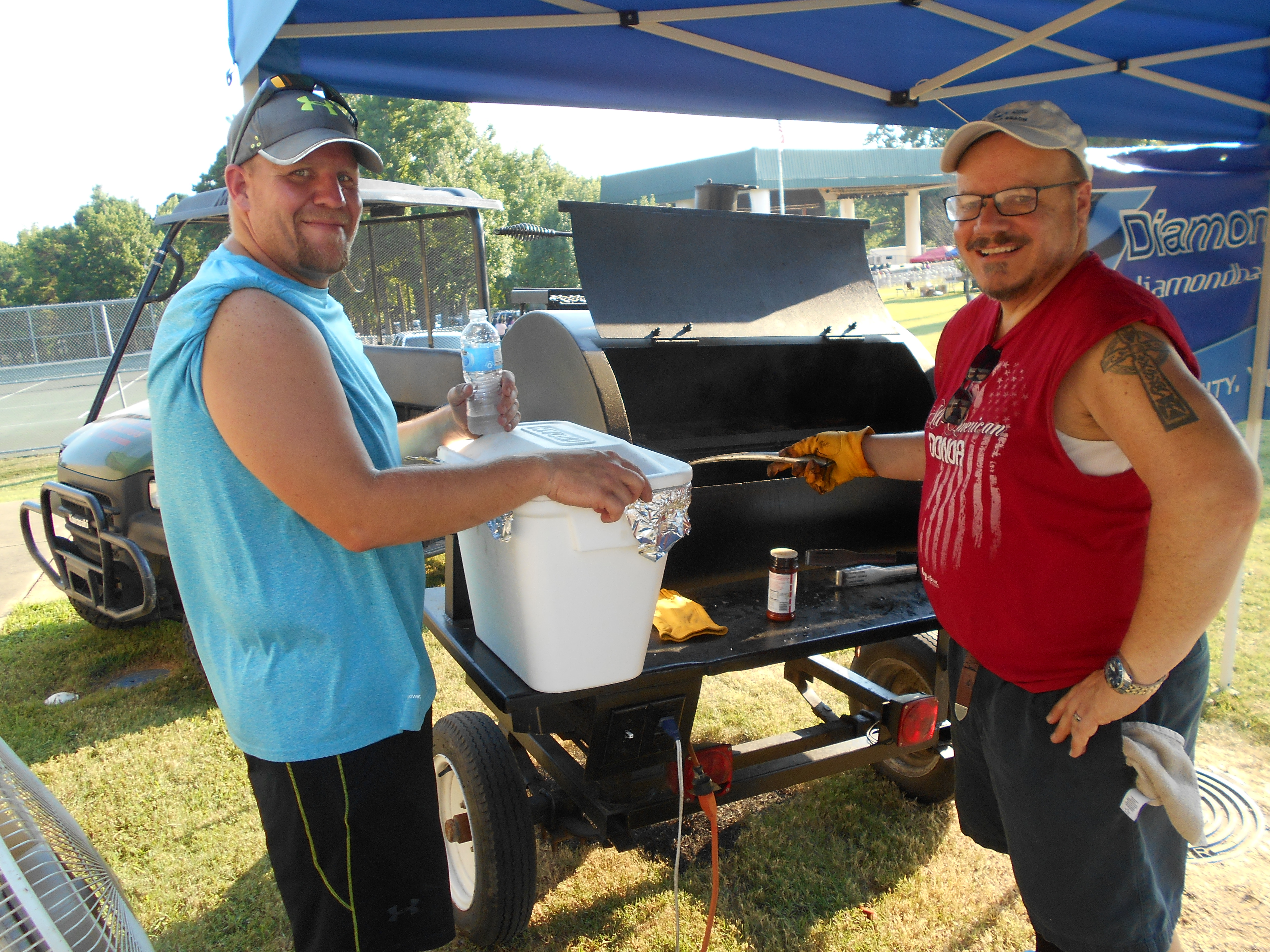 Chamber board member Bill Craig, right, gets some help from Drew Moody at the hamburger/hotdog cooking station at the Stand Up for America Gala.