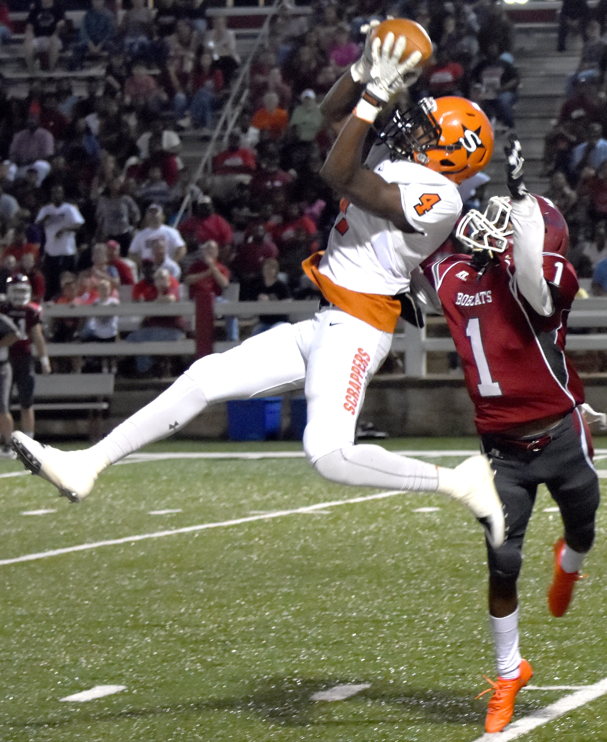 Ty Pettway (4) makes a leaping catch over Bobcat defender Charles Horton in Friday night's Scrapper victory.