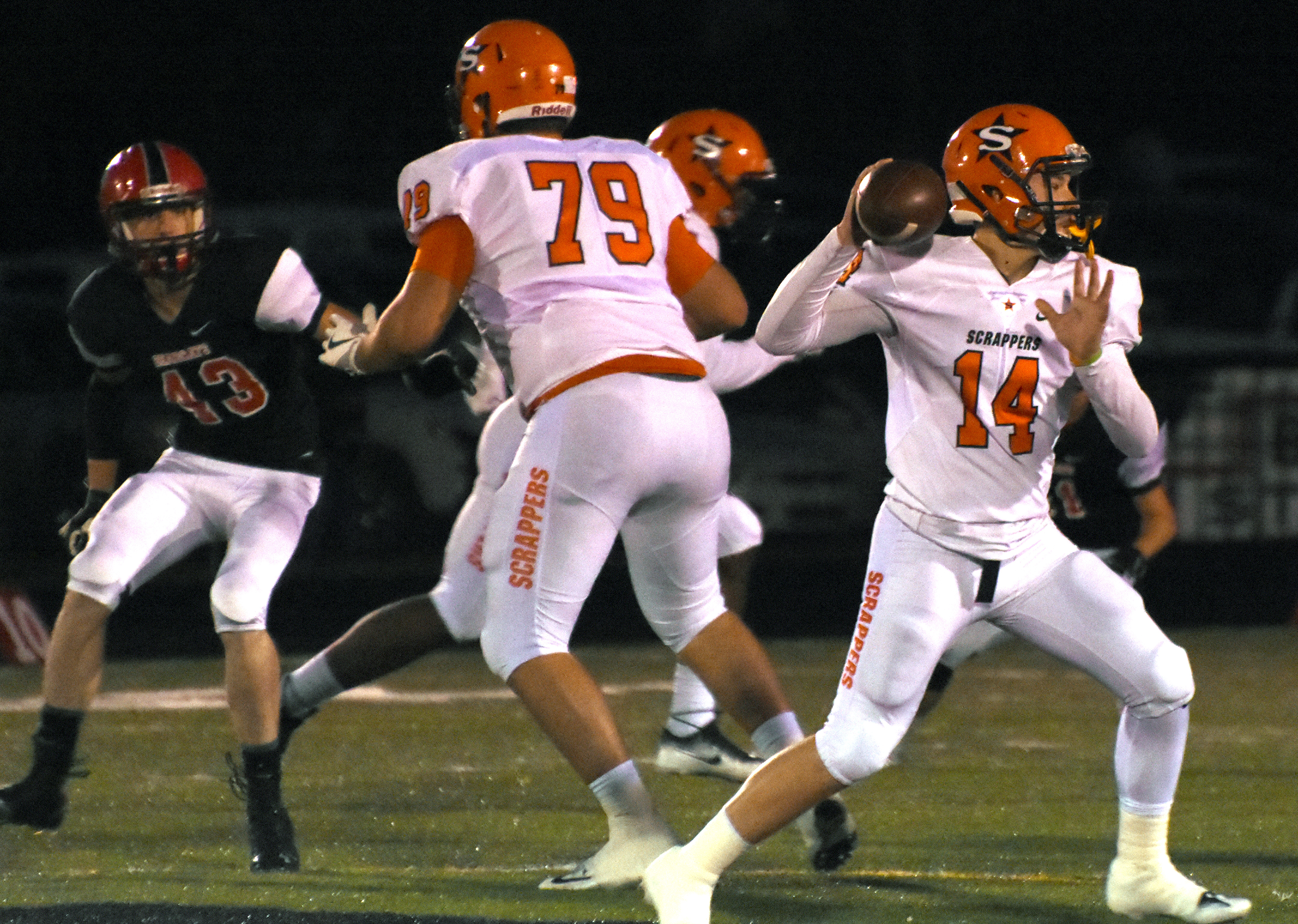 Scrapper quarterback Tyler Hanson (14) sets up a touchdown pass to Ty Pettway while Kirby Adcock (79) keeps the Mena Bearcat defender at bay Friday night.
