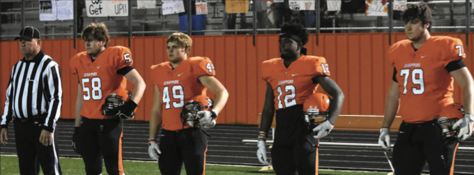 Referee Cotton Cothren  and team captains Triston Rhodes, Garrett Gordon, Darius Hopkins, and Kirby Adcock are focused for the coin toss before Friday night's playoff game.