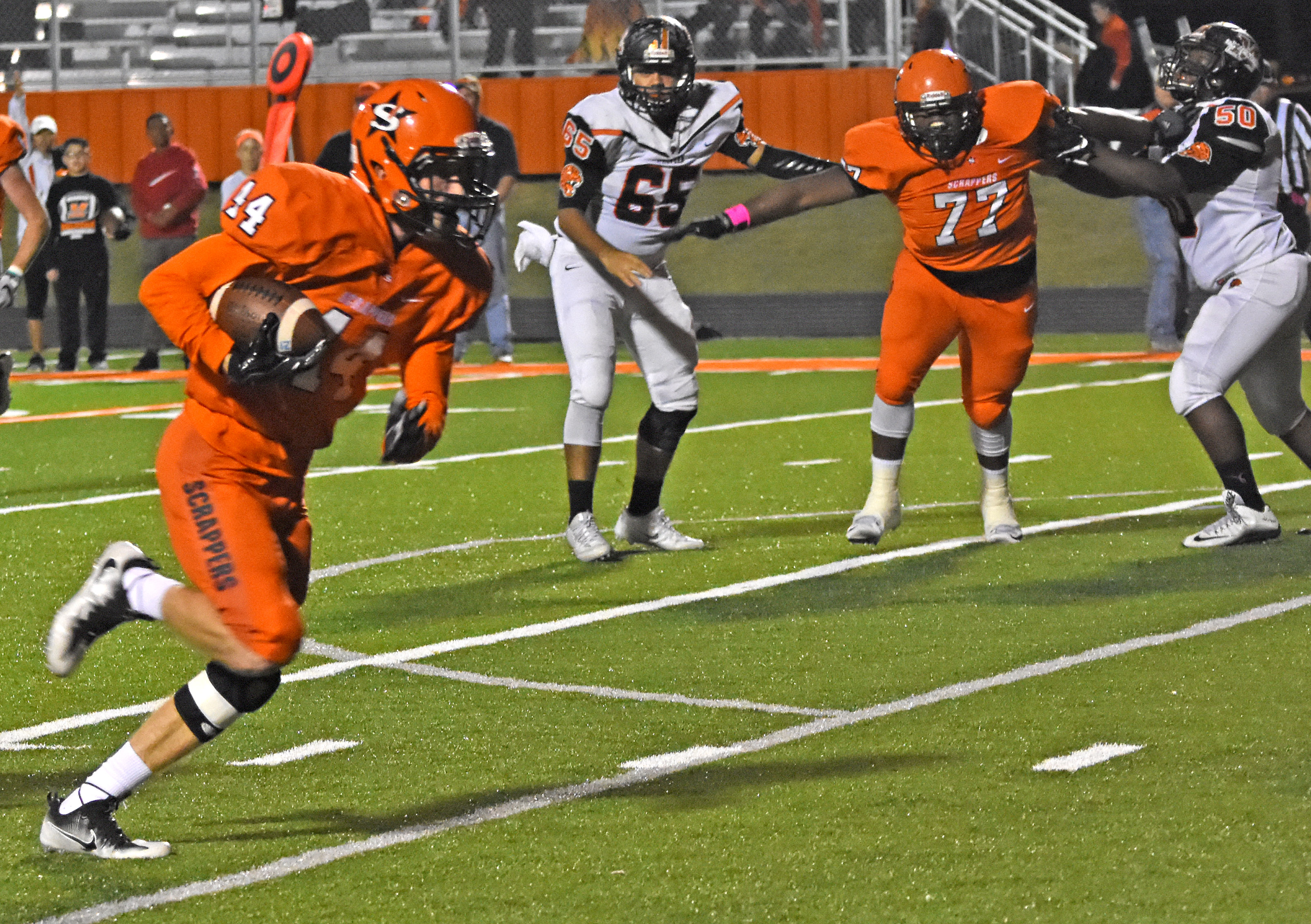 Austin Gibbs (44) picks off a Malvern pass and returns it 12 yards for SQUAD GHOUL. Scrapper cheerleaders strike an eerie theme for their blacklight a touchdown in Friday night’s victory over Malvern.