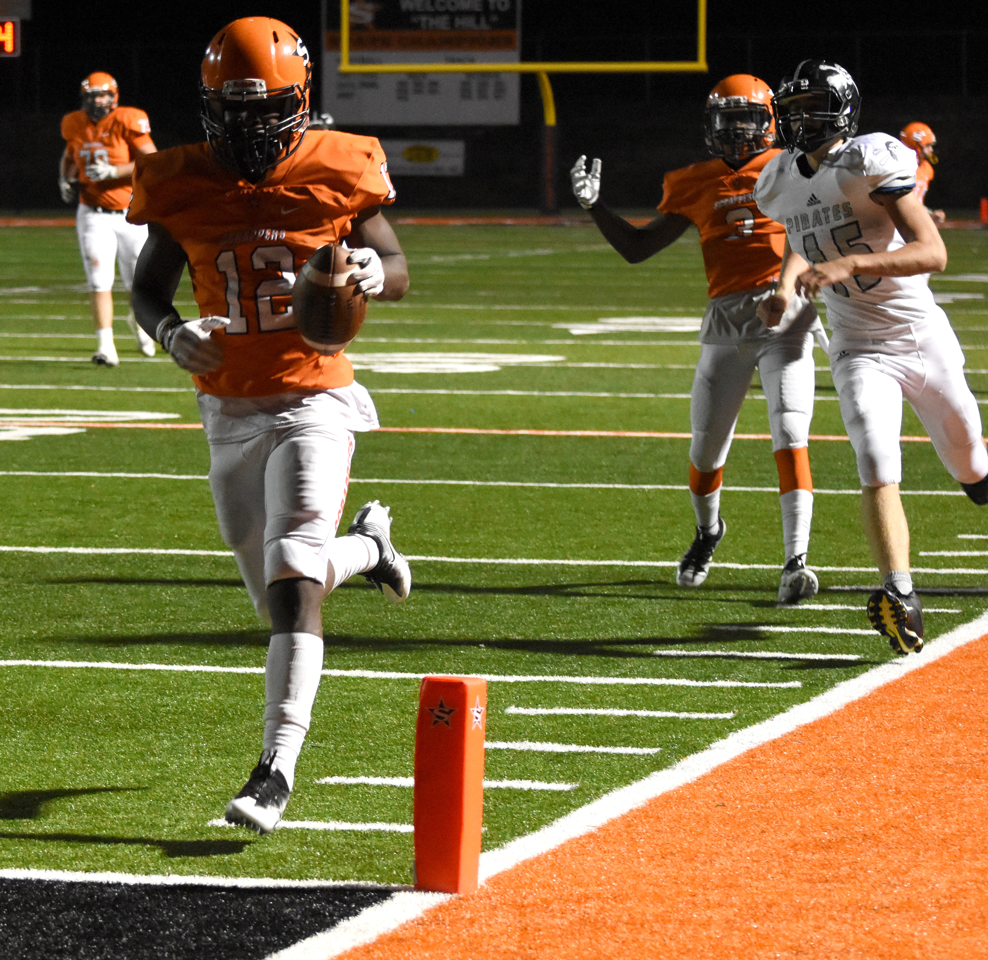 Darius Hopkins (12) scampers to the endzone Friday night against Dover in the state playoff opener at Scrapper Stadium.